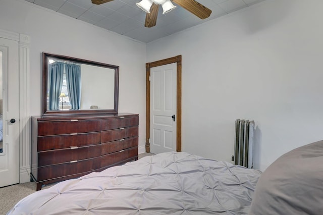 carpeted bedroom with radiator and ceiling fan