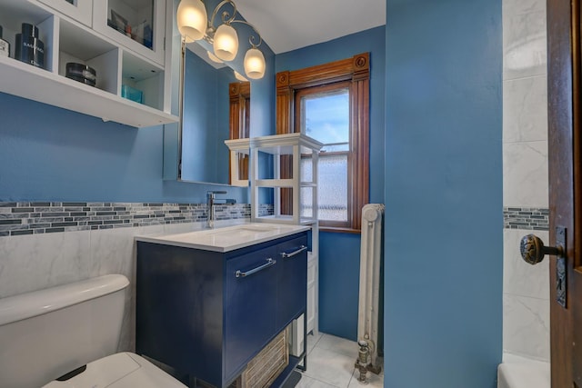 bathroom with vanity, tile patterned floors, tile walls, and toilet