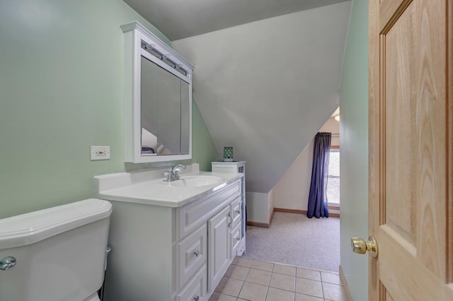 bathroom featuring vanity, vaulted ceiling, tile patterned floors, and toilet