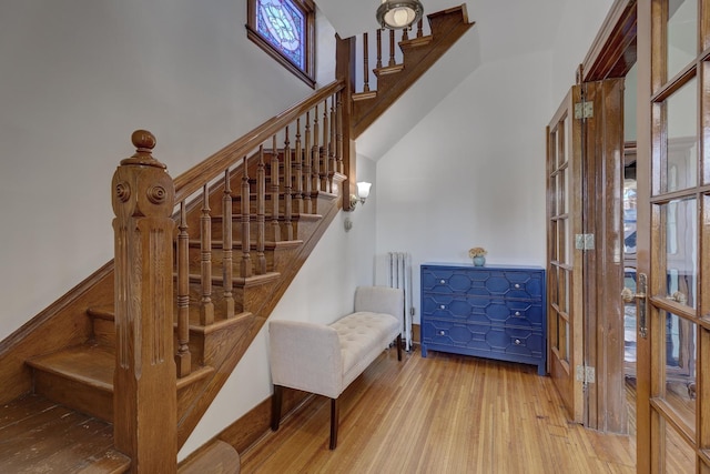 staircase with hardwood / wood-style flooring and a towering ceiling