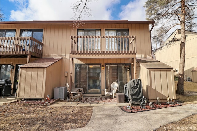 back of house featuring a balcony and central AC unit