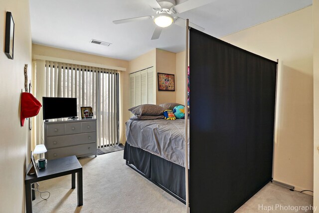 bedroom featuring ceiling fan, a closet, and light carpet