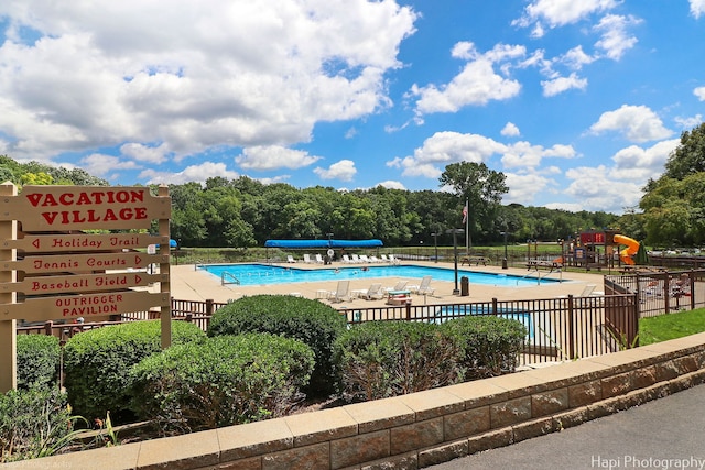 view of pool featuring a playground and a patio