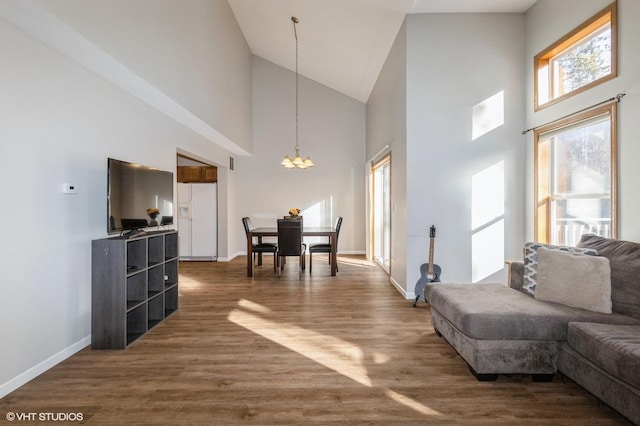 living room featuring dark hardwood / wood-style flooring, high vaulted ceiling, and an inviting chandelier