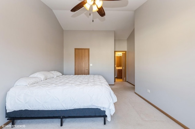 bedroom featuring ceiling fan, ensuite bathroom, light carpet, and lofted ceiling