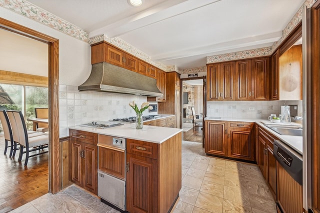 kitchen with wall chimney range hood, decorative backsplash, sink, and dishwasher