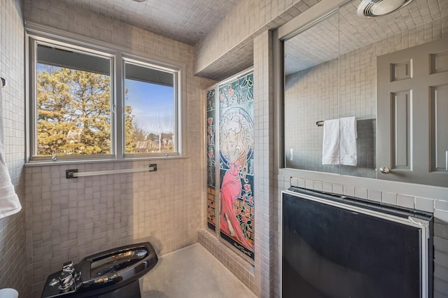 bathroom with tile walls and toilet