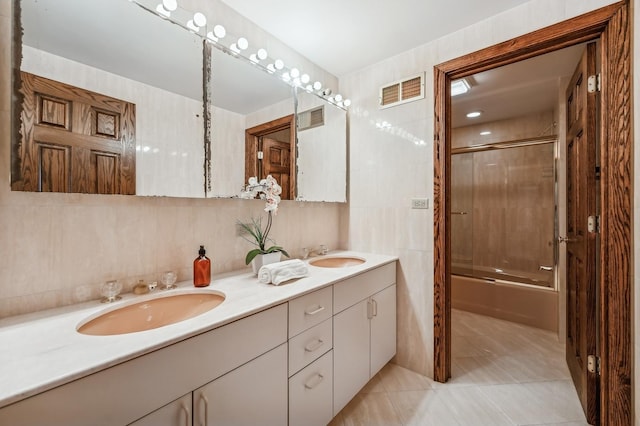 bathroom with tile walls, tiled shower / bath combo, vanity, tasteful backsplash, and tile patterned floors