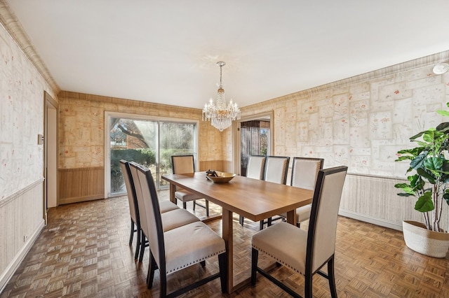 dining area featuring dark parquet floors and a notable chandelier