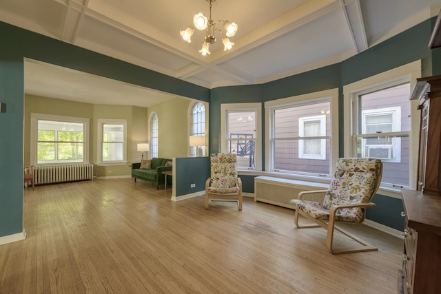 sitting room with beamed ceiling, coffered ceiling, radiator heating unit, and light hardwood / wood-style flooring