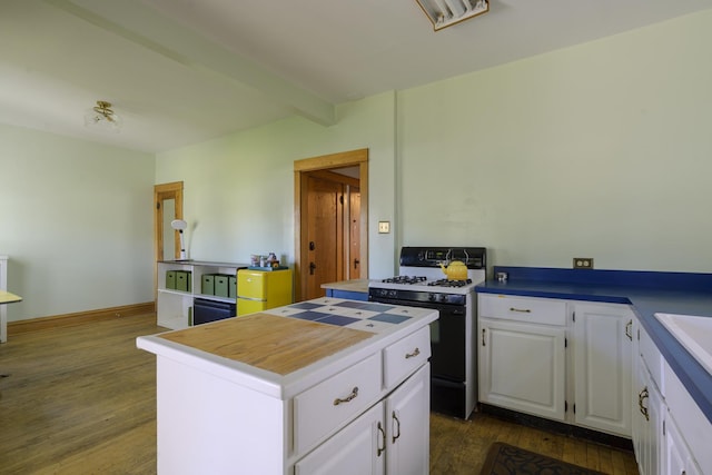 kitchen featuring dark wood-type flooring, a kitchen island, beam ceiling, black gas range, and white cabinets