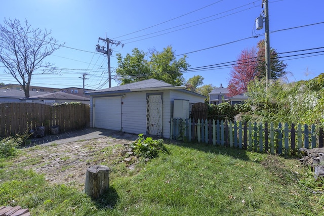 view of yard featuring a garage and an outbuilding