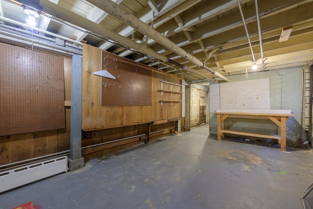 basement featuring a workshop area and baseboard heating