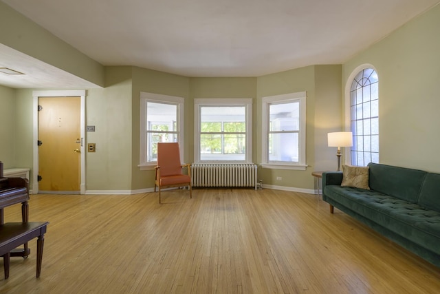 sitting room with radiator heating unit and light wood-type flooring