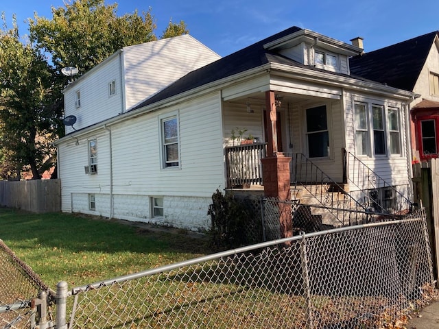 view of side of property with a yard and covered porch