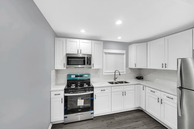 kitchen featuring appliances with stainless steel finishes, sink, and white cabinets