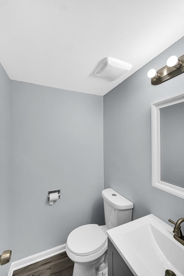 bathroom with vanity, hardwood / wood-style flooring, and toilet