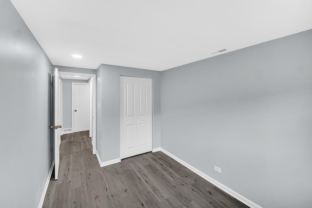 unfurnished bedroom featuring hardwood / wood-style flooring and a closet