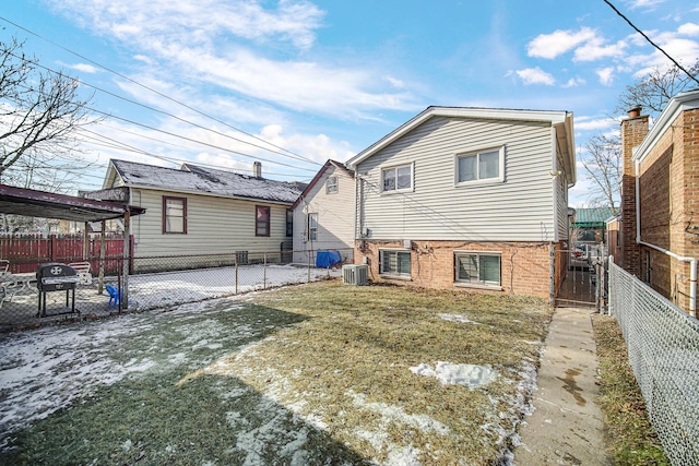 rear view of property featuring a yard and central air condition unit