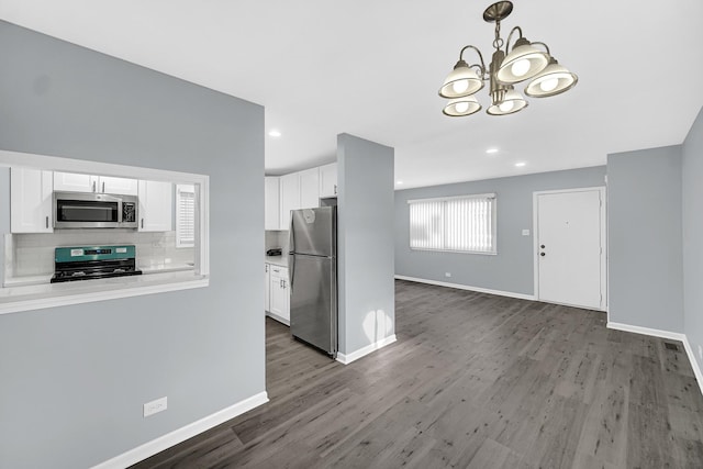 kitchen featuring pendant lighting, white cabinetry, stainless steel appliances, dark hardwood / wood-style flooring, and decorative backsplash