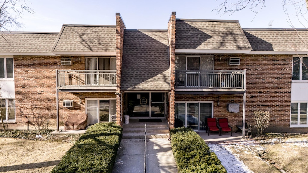 view of front of house featuring a balcony and a patio area