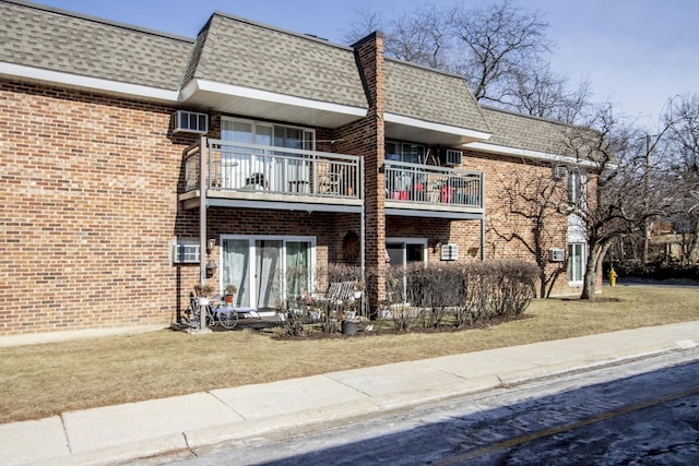 rear view of property with a balcony and a yard