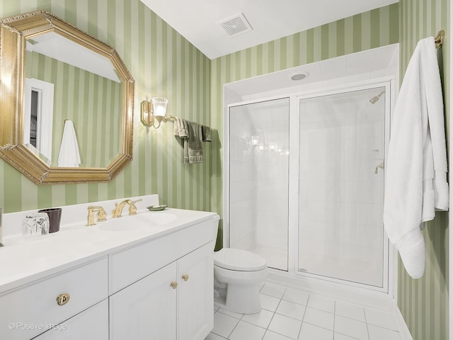 bathroom featuring a shower with door, vanity, tile patterned floors, and toilet