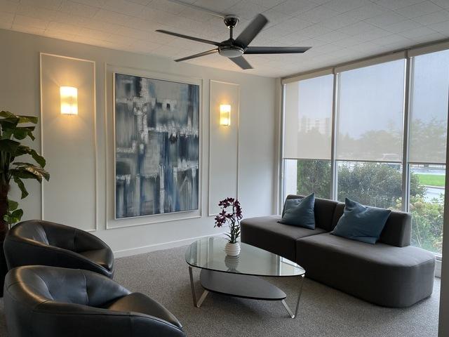 living area with a wall of windows, carpet flooring, and a ceiling fan