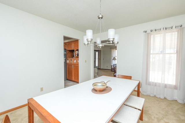 carpeted dining room with plenty of natural light and a chandelier