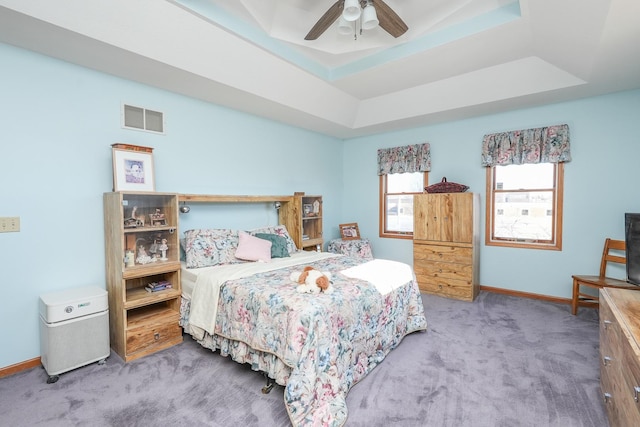 bedroom featuring carpet floors, a raised ceiling, and ceiling fan