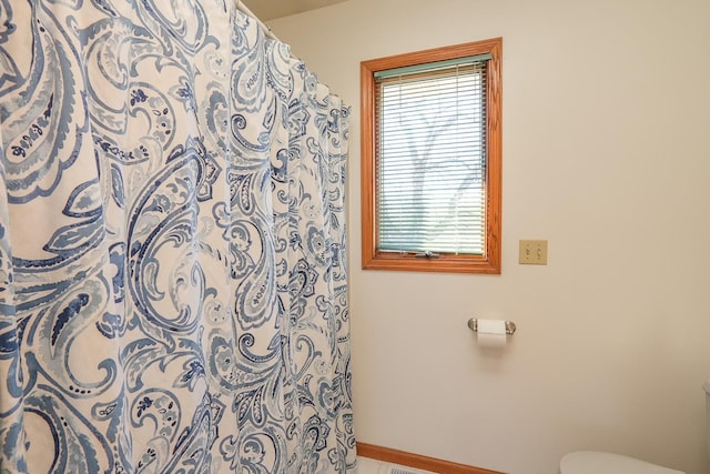 bathroom with tile patterned floors, toilet, and walk in shower