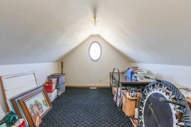 bonus room featuring lofted ceiling, dark carpet, and a textured ceiling