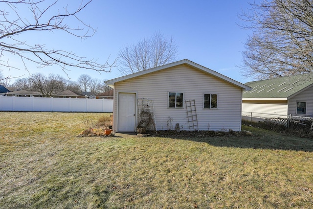 rear view of property featuring a lawn