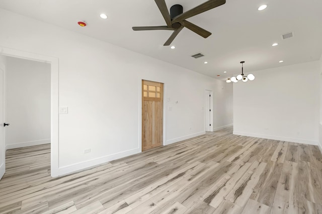 unfurnished room featuring ceiling fan with notable chandelier and light wood-type flooring