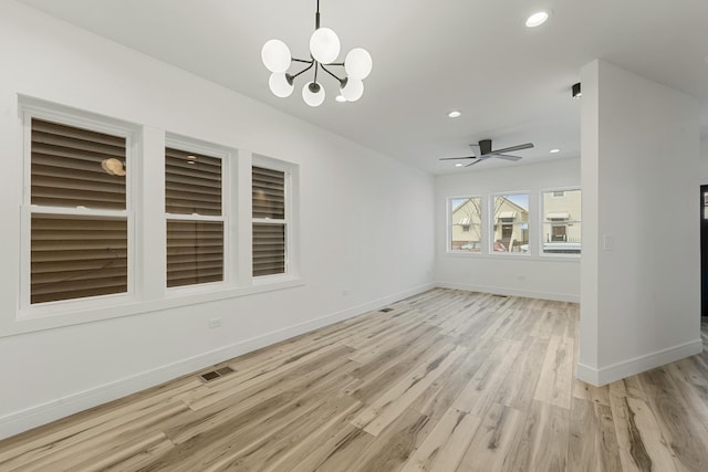 interior space featuring ceiling fan with notable chandelier and light hardwood / wood-style floors