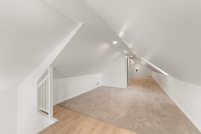 additional living space featuring lofted ceiling and light wood-type flooring