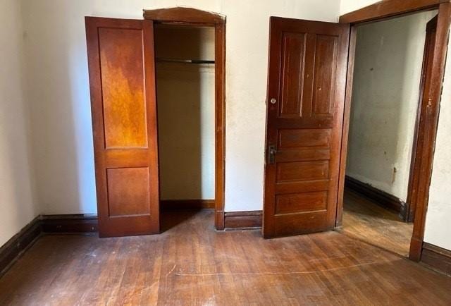 unfurnished bedroom featuring a closet and dark hardwood / wood-style floors