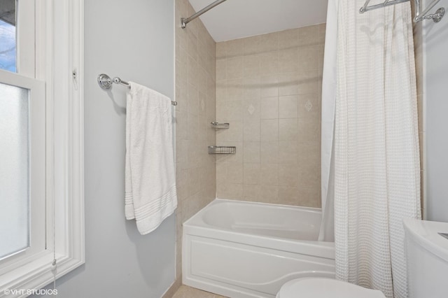 bathroom featuring shower / tub combo with curtain and toilet