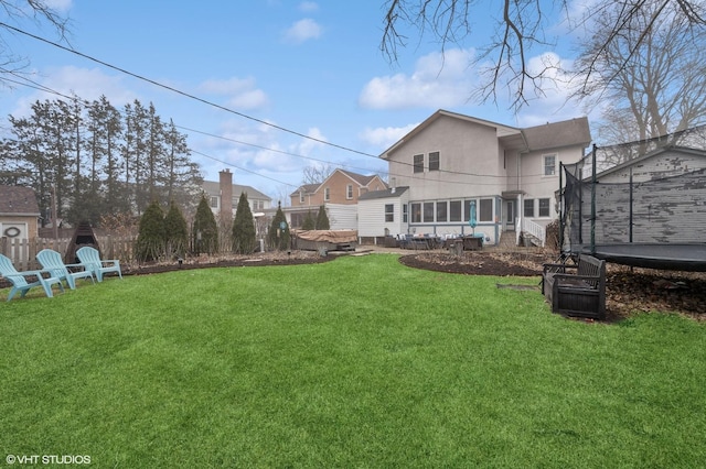 rear view of house featuring a yard, a patio, and a trampoline