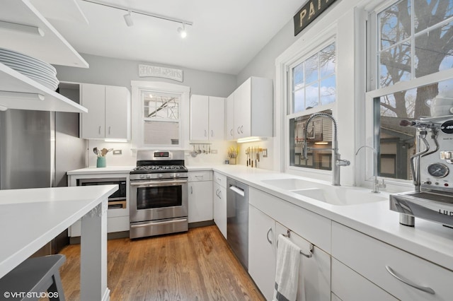 kitchen with white cabinetry, appliances with stainless steel finishes, dark wood-type flooring, and sink