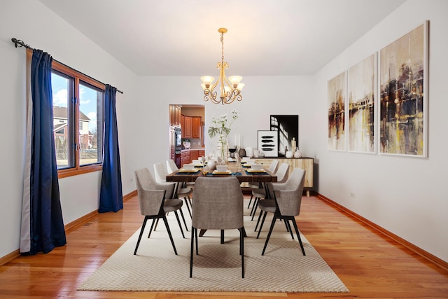 dining area with a chandelier and light hardwood / wood-style floors