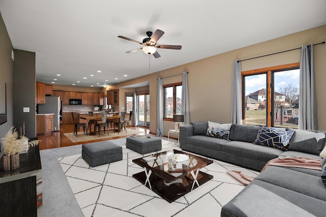 living room featuring ceiling fan, a healthy amount of sunlight, and light hardwood / wood-style floors