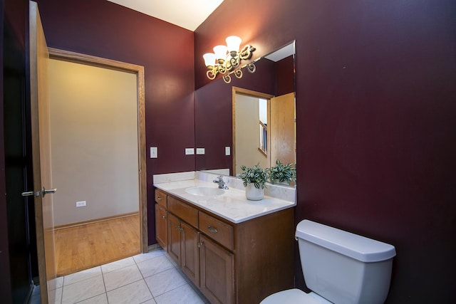 bathroom featuring vanity, toilet, tile patterned flooring, and a notable chandelier