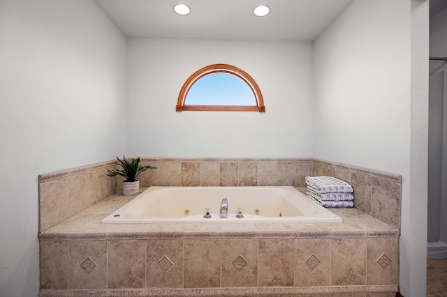 bathroom with sink and tiled tub