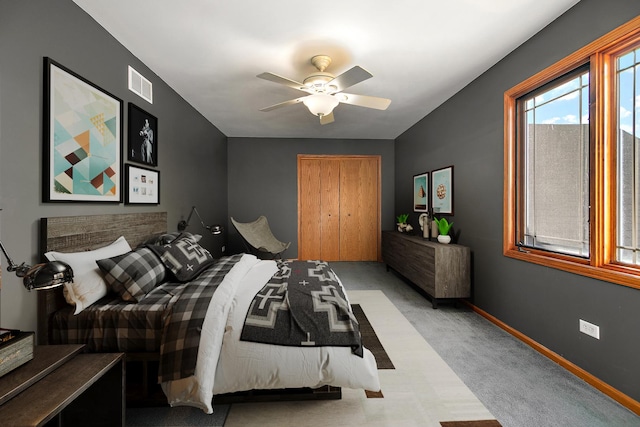 bedroom with light carpet, ceiling fan, and a closet