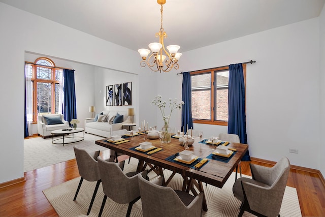 dining space featuring a notable chandelier, light hardwood / wood-style flooring, and a healthy amount of sunlight