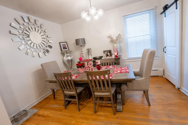 dining space featuring a barn door, baseboards, a baseboard radiator, wood-type flooring, and a notable chandelier