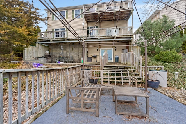 back of property featuring a wooden deck, a patio area, and a balcony