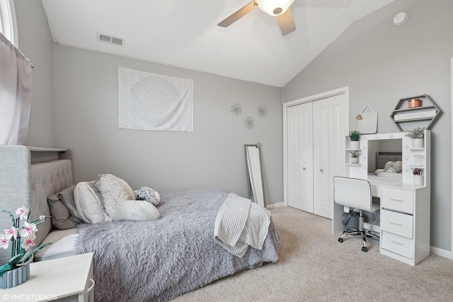 carpeted bedroom with vaulted ceiling, a closet, and ceiling fan