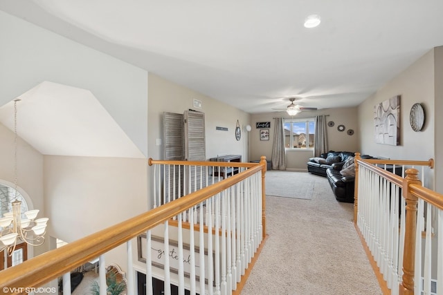 hallway featuring light carpet and a chandelier